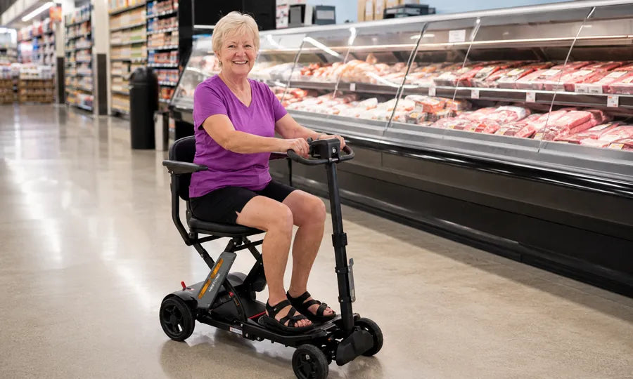 A senior woman using the Meet One Glide mobility scooter while shopping in a grocery store.